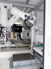 A six-axis articulated robot removes finished test components from the four-cavity mould, placing them onto a small load carrier