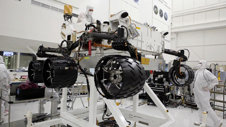 Engineers install wheels on the Curiosity rover in the cleanroom at the NASA Jet Propulsion Laboratory in Pasadena, California. <br> Credit: NASA/JPL-Caltech